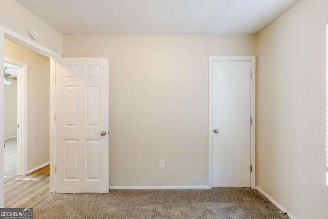 unfurnished bedroom featuring baseboards and light carpet