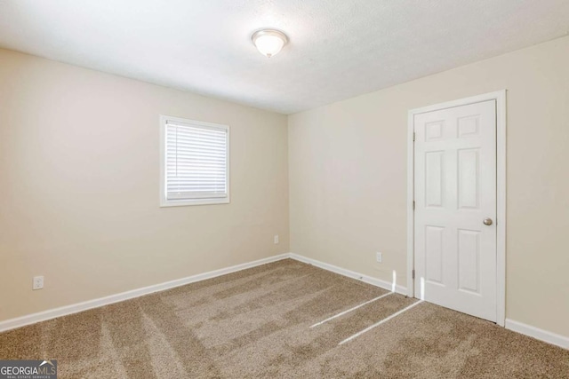 empty room with baseboards and carpet flooring