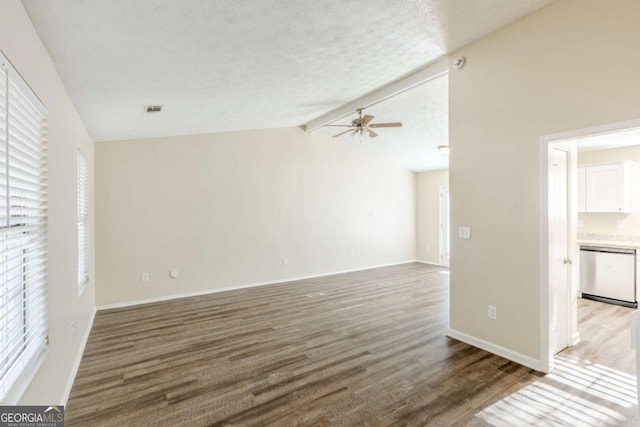 unfurnished living room with baseboards, vaulted ceiling with beams, a ceiling fan, and wood finished floors