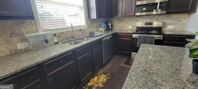 kitchen with dark wood-type flooring, light stone countertops, decorative backsplash, stainless steel appliances, and a sink