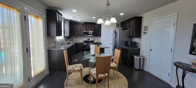 kitchen with a sink, plenty of natural light, a chandelier, and stainless steel appliances