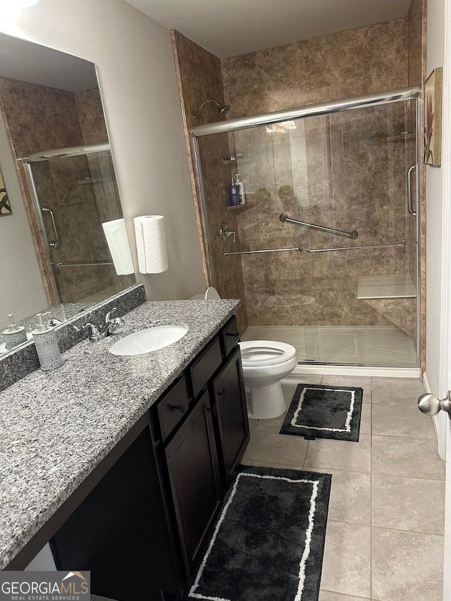 full bath featuring vanity, toilet, a shower stall, and tile patterned flooring