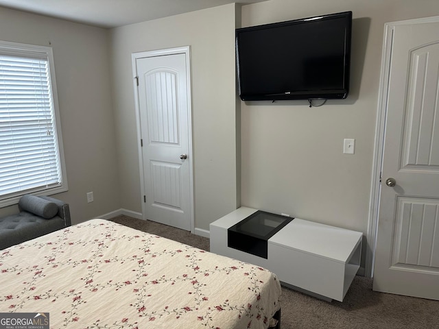 bedroom with baseboards and dark colored carpet