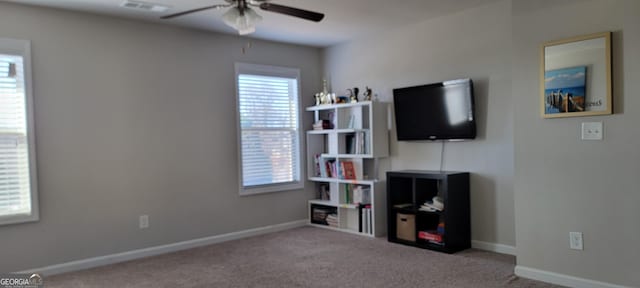 carpeted living area featuring visible vents, baseboards, and ceiling fan