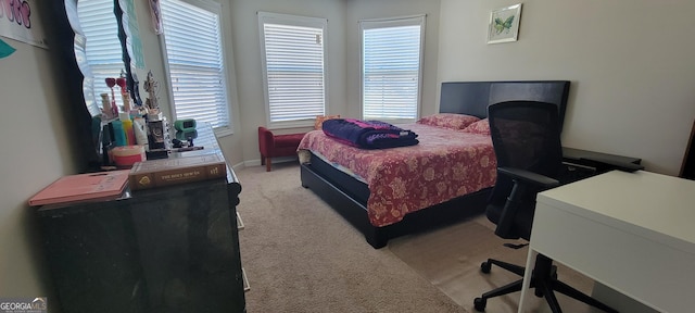 bedroom featuring light carpet and multiple windows