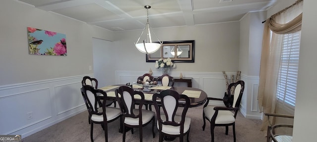 carpeted dining area with visible vents, a wainscoted wall, coffered ceiling, beamed ceiling, and a decorative wall