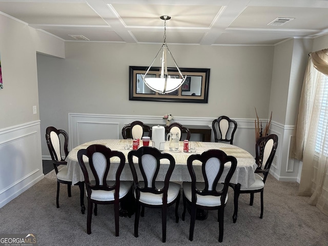 carpeted dining room featuring visible vents and wainscoting