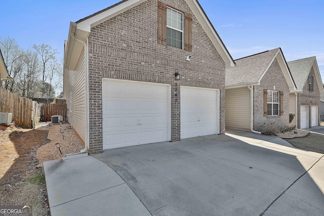 view of side of home featuring central AC unit, fence, brick siding, and driveway