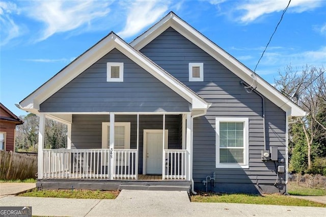 bungalow-style house with covered porch and fence