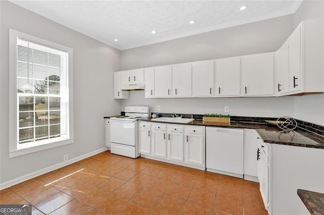 kitchen featuring baseboards, under cabinet range hood, white cabinets, white appliances, and a sink