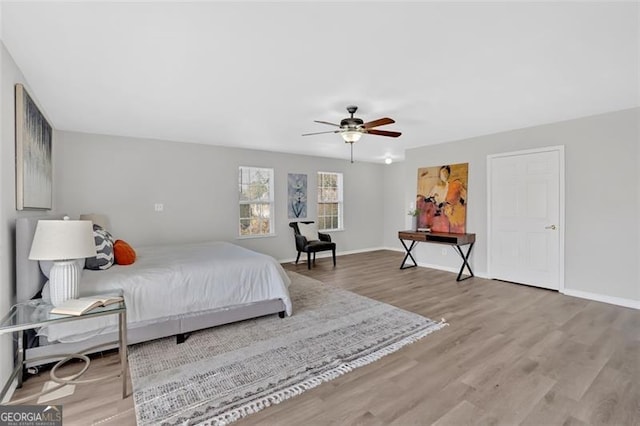 bedroom with ceiling fan, baseboards, and wood finished floors