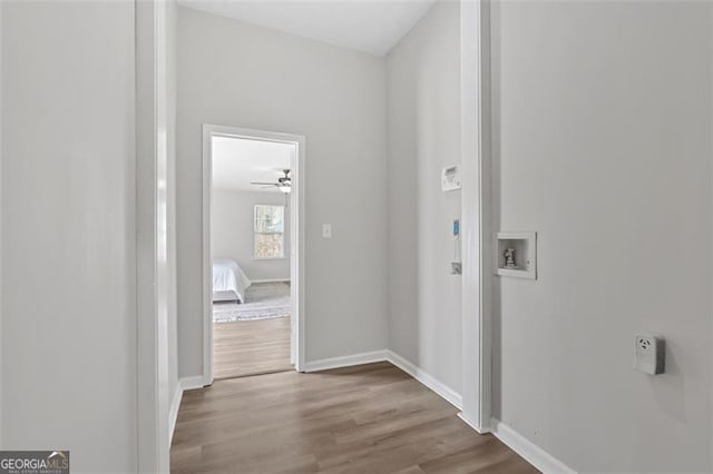 corridor featuring wood finished floors and baseboards