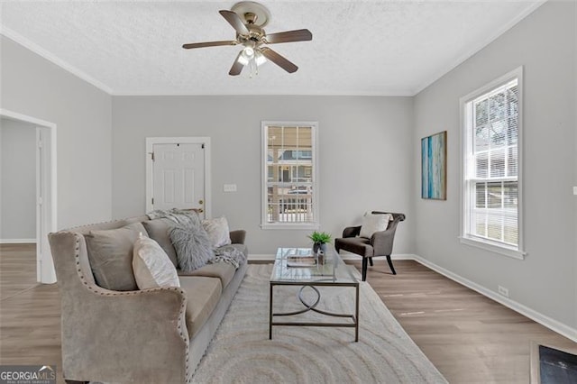 living area with a textured ceiling, a ceiling fan, and wood finished floors