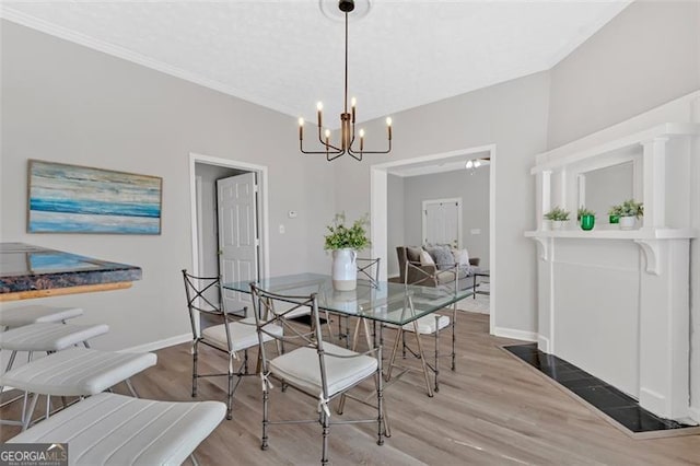 dining space with a chandelier, ornamental molding, baseboards, and wood finished floors