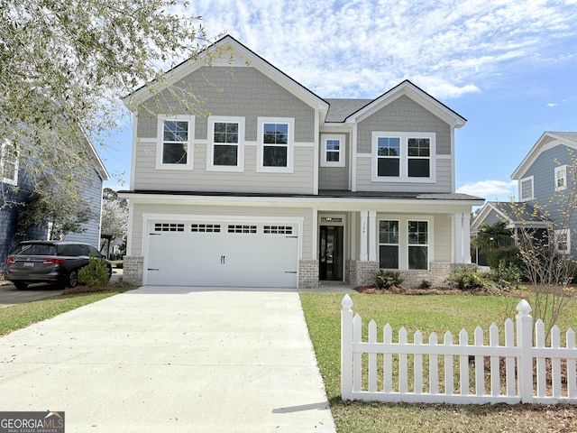 craftsman house featuring a front yard, fence, driveway, an attached garage, and brick siding