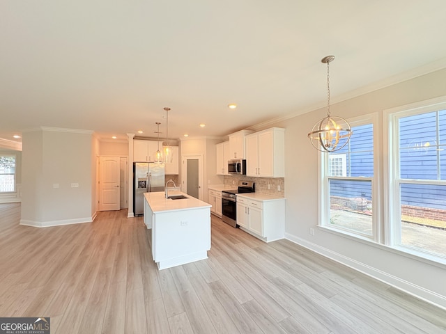 kitchen with light wood-style flooring, a sink, stainless steel appliances, backsplash, and a chandelier