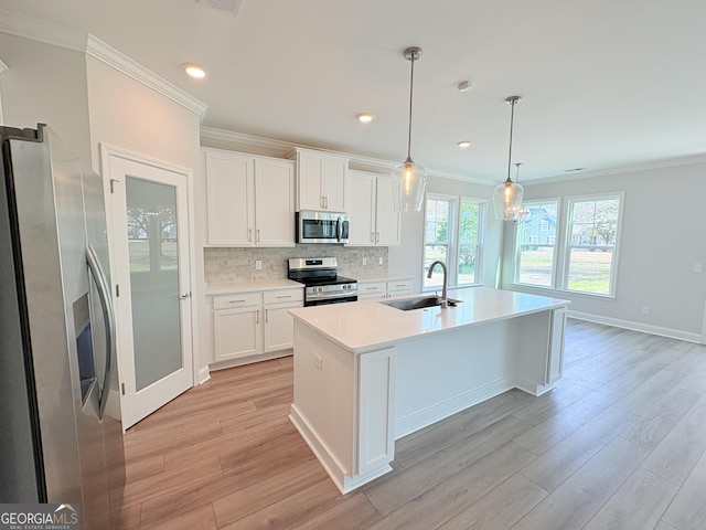 kitchen with crown molding, decorative backsplash, appliances with stainless steel finishes, light wood-style floors, and a sink