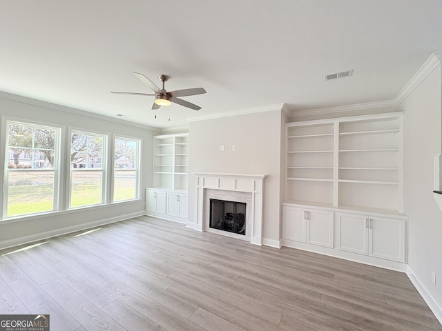 unfurnished living room featuring visible vents, wood finished floors, a fireplace, and crown molding