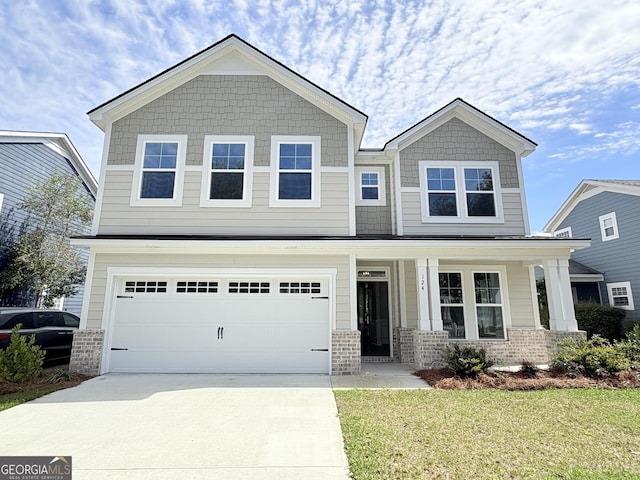 view of front of house with brick siding, a front lawn, a porch, concrete driveway, and an attached garage