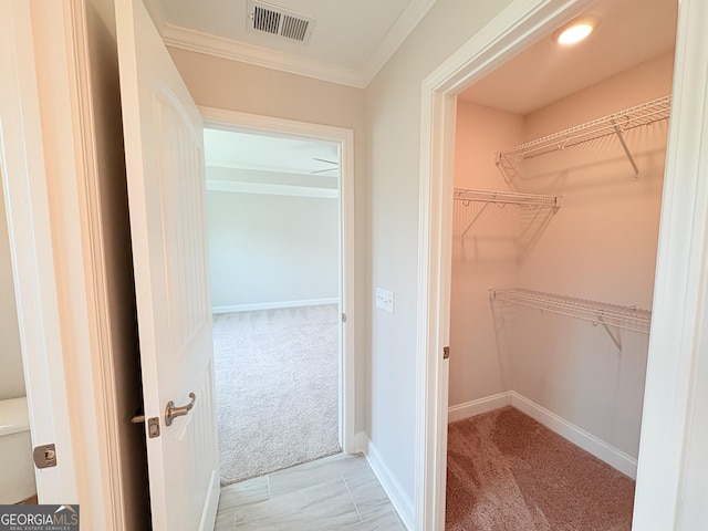 walk in closet featuring visible vents and light colored carpet