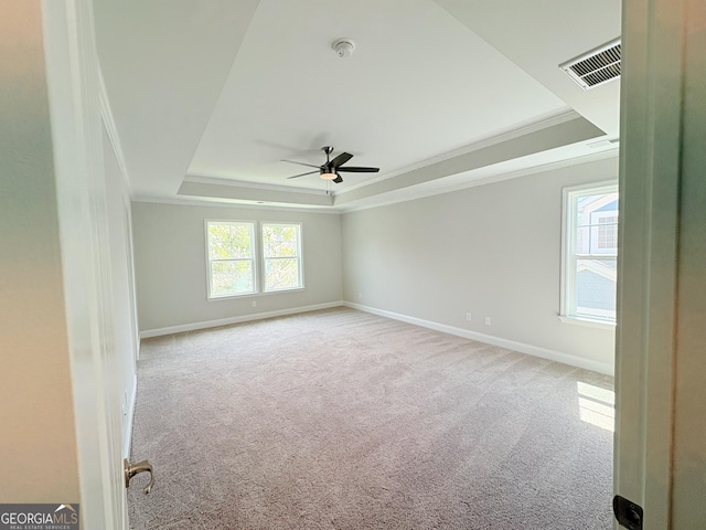 spare room featuring visible vents, ornamental molding, baseboards, carpet flooring, and a raised ceiling