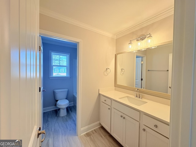 bathroom featuring vanity, crown molding, toilet, and baseboards