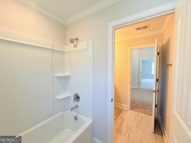 bathroom featuring visible vents, shower / bathtub combination, baseboards, and ornamental molding