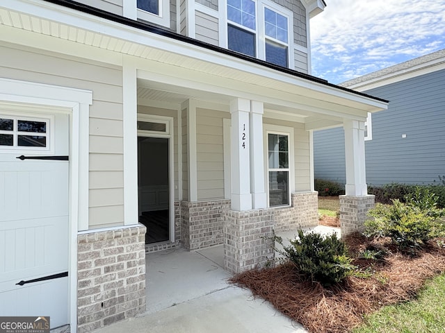 doorway to property with covered porch and a garage