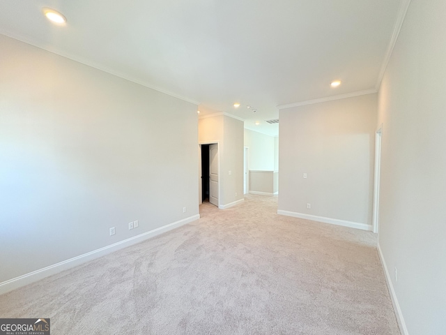 spare room featuring light colored carpet, recessed lighting, baseboards, and ornamental molding