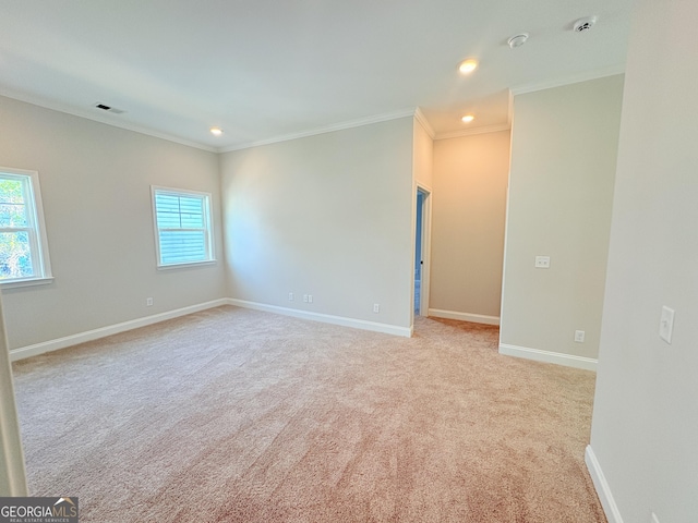 empty room with light colored carpet, baseboards, a wealth of natural light, and ornamental molding