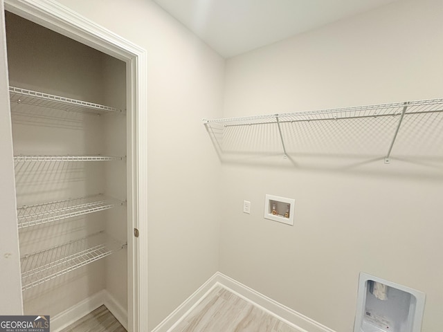 washroom with light wood finished floors, laundry area, hookup for a washing machine, and baseboards