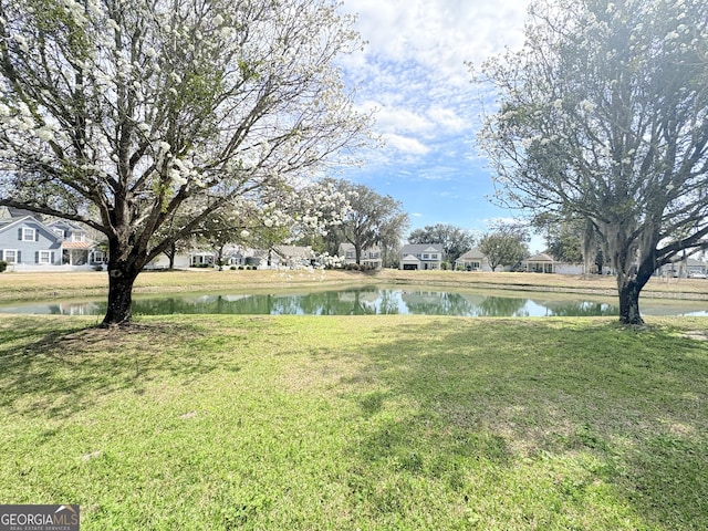 view of yard with a residential view and a water view