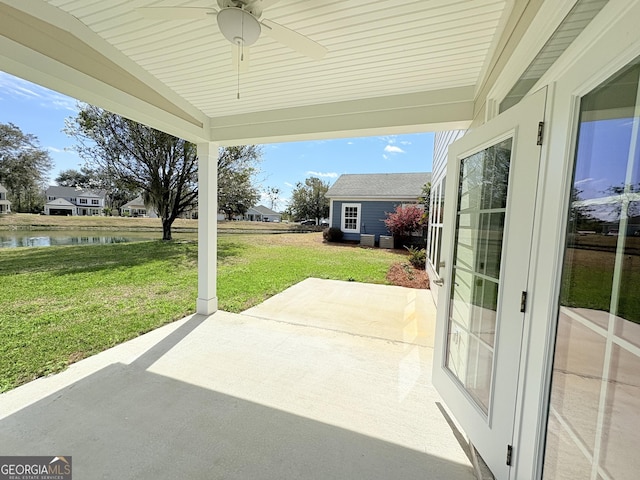 view of patio featuring a ceiling fan and a water view