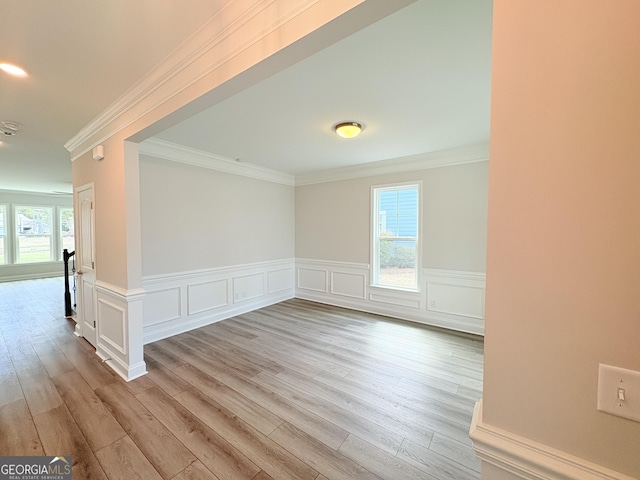 spare room featuring wainscoting, ornamental molding, and wood finished floors