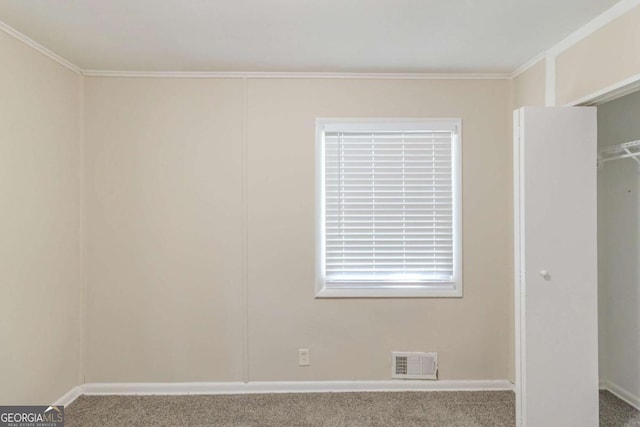 unfurnished room with visible vents, carpet floors, and ornamental molding