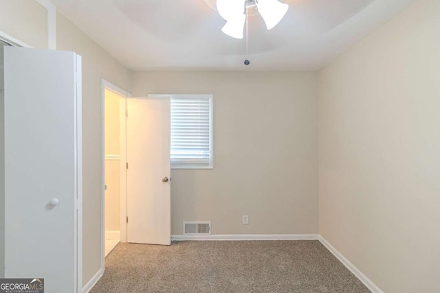 unfurnished bedroom with a ceiling fan, carpet flooring, baseboards, and visible vents