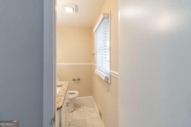 half bath with visible vents, baseboards, toilet, marble finish floor, and vanity