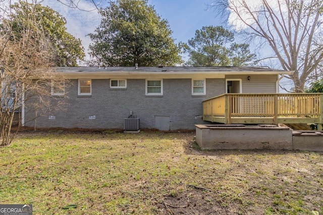 back of property featuring brick siding, a wooden deck, cooling unit, a yard, and crawl space