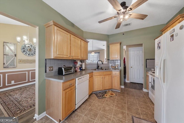 kitchen with a sink, visible vents, white appliances, and light brown cabinets