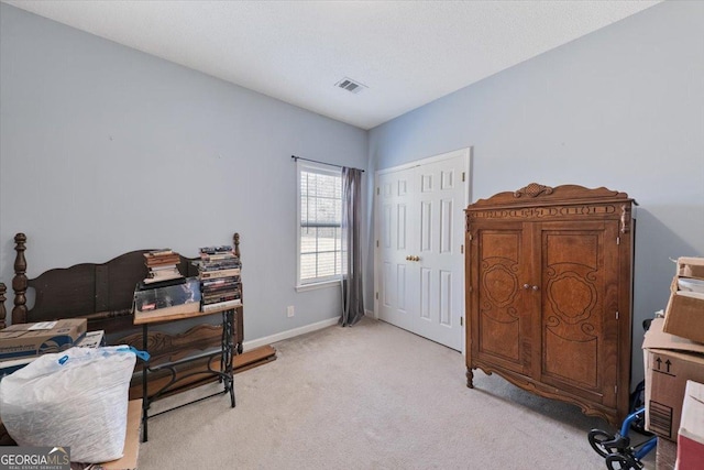 office area with visible vents, light colored carpet, and baseboards