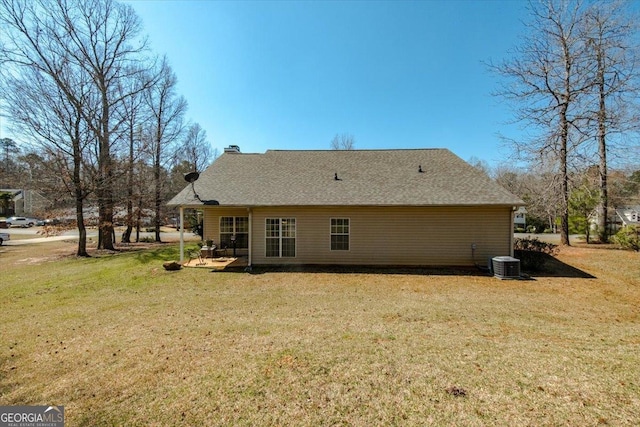 back of property with a yard, central air condition unit, a chimney, and a patio area