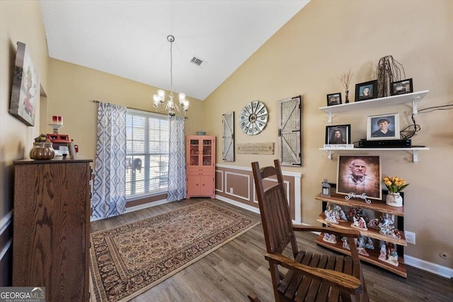 interior space featuring vaulted ceiling, a notable chandelier, wood finished floors, and visible vents