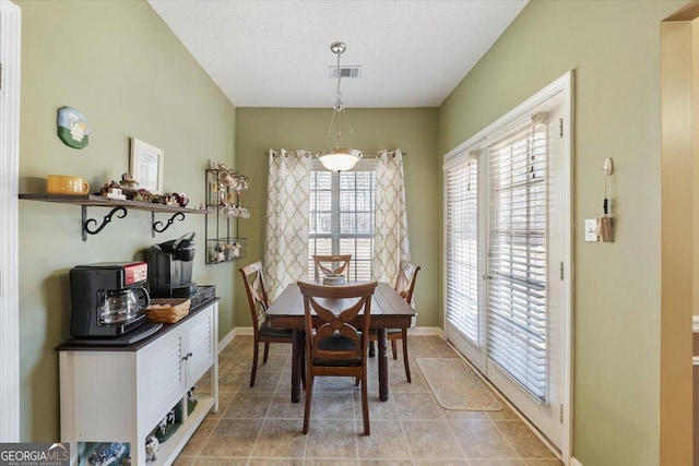 dining space with light tile patterned floors, baseboards, visible vents, and a textured ceiling