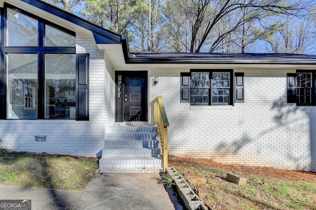 view of exterior entry with brick siding