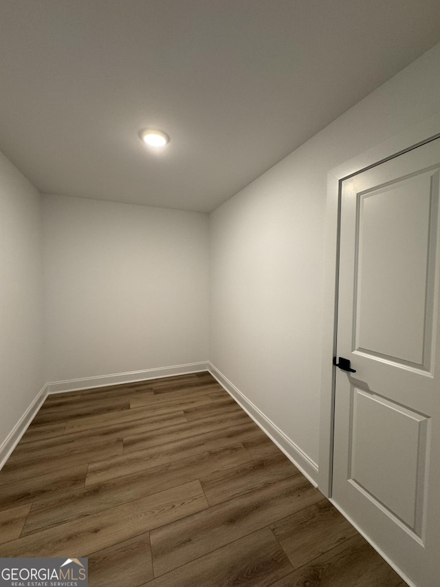 spare room with dark wood finished floors and baseboards