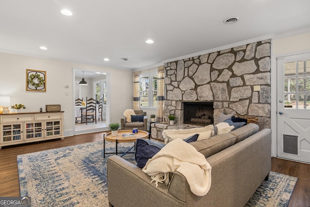 living room featuring a wealth of natural light, visible vents, and ornamental molding