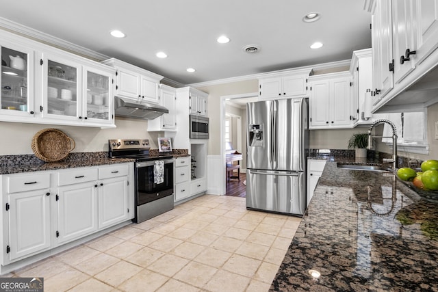 kitchen with visible vents, under cabinet range hood, dark stone counters, appliances with stainless steel finishes, and a sink