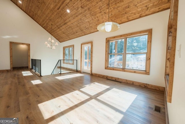 empty room featuring wood finished floors, baseboards, visible vents, high vaulted ceiling, and wood ceiling