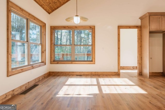 unfurnished dining area featuring visible vents, light wood-type flooring, baseboards, and vaulted ceiling