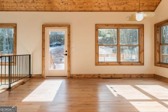 doorway featuring visible vents, baseboards, and wood finished floors